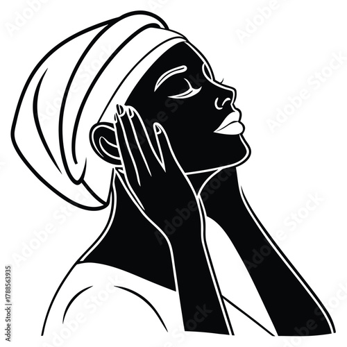 Black and white silhouette of woman with towel on head applying facial massage