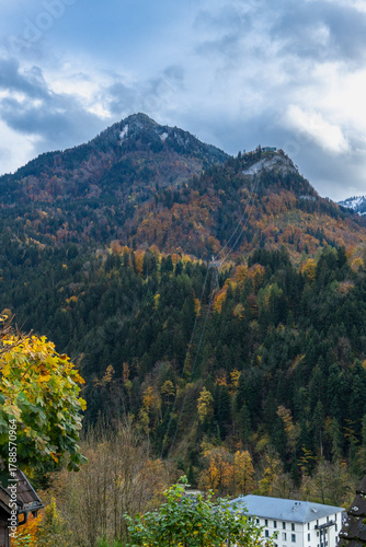 peak from mountain, steep slope, mountainside with forests, autumnal colored under cloudy sky, steep meadow with autumnal trees, viewpoint on hill, hiking area through autumn trees
