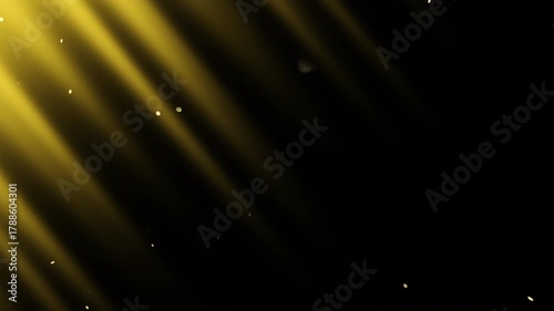 Diagonal beams of yellow light shimmer in the darkness and slowly  flying fairy dust. 4K slow motion video at 60 fps.