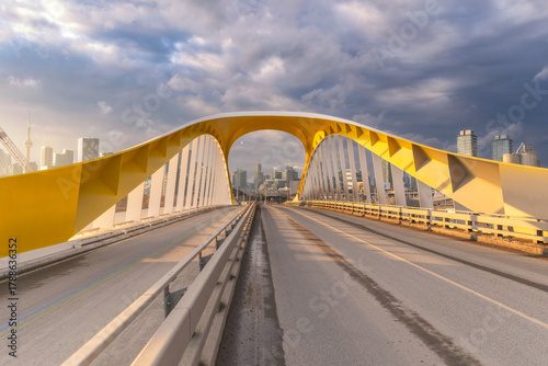 Yellow bridge with dramatic clouds at sunset - Cherry Street South Bridge with the Toronto skyline in the background