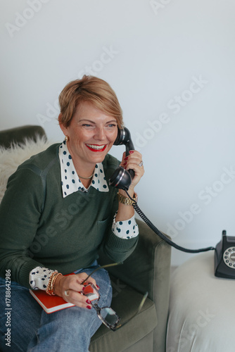 Midlife entrepreneur woman talking on vintage phone