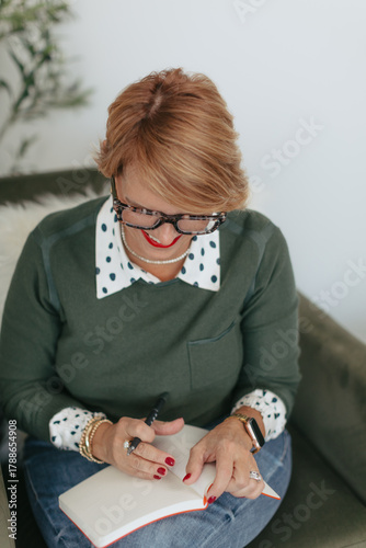Midlife woman entrepreneur taking notes in journal