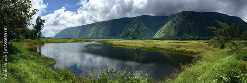 Stunning Waipio Valley Landscape: Lush Green Countryside Under a Dramatic Sky with Crystal Clear Lake and Rolling Fields