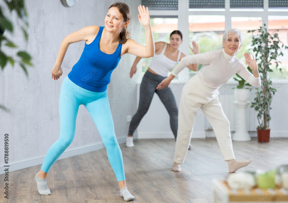 Obraz premium Happy different ages women learning swing steps at dance class
