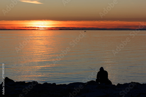 Fisherman seen in silhouette during a spectacular sunset