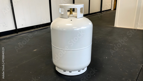 A pristine white propane tank stands upright on a matte black concrete surface, its smooth, powder-coated finish glowing with a soft, even sheen under cool