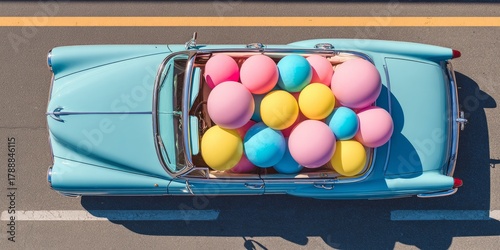 Flat lay photography of convertible car full with beach balls on highway, light pink, blue and yellow colors
