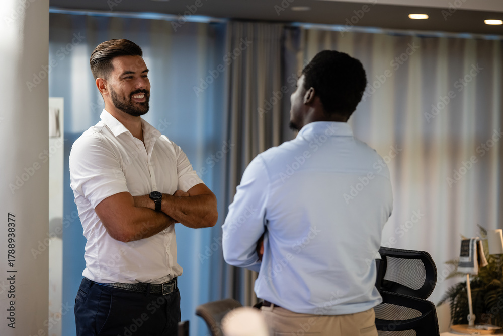 Obraz premium Two businessmen engaged in friendly office conversation