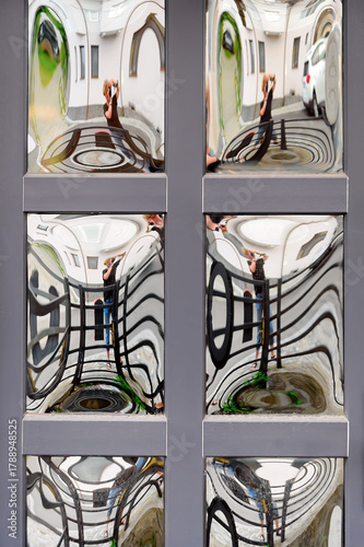 A wooden door panel with square curved mirrored glass inserts