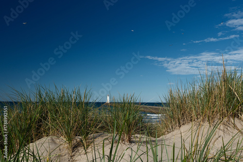 Sand Dunes, grasses and The Sodus Point Lighhtouse and pier on Lake Ontario New York State on a perfect afternoon