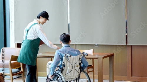 カフェスタッフが車椅子のお客様を案内しているシーン