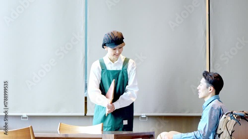 カフェスタッフが車椅子のお客様を案内しているシーン