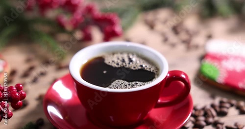Pouring aromatic coffee into cup, beans and Christmas decor at table, closeup