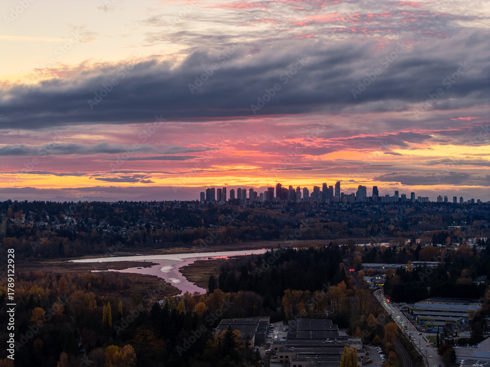 Fototapeta premium Sunset Over Burnaby Skyline Across Greater Vancouver With River, Trees, And City Lights