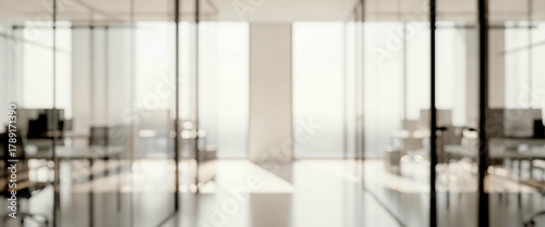 Bright blurred modern office interior with daylight and neutral tones. Contemporary workspace with structured lighting and clean design, suitable for business backgrounds.
