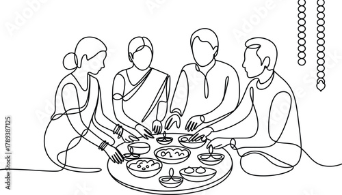 Family gathered around table with food and diyas gathering
