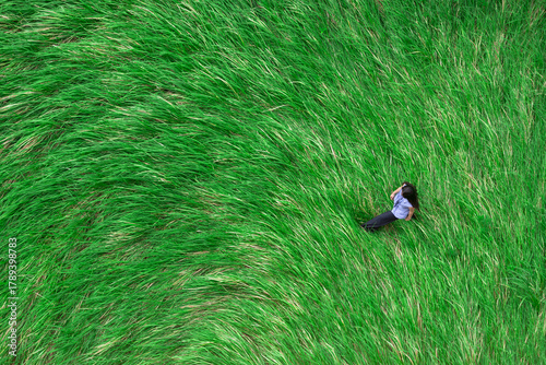 Aerial photography of a girl walking on a long grassland
