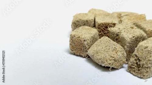 Frozen tubifex worms on a white background. These worms are used as valuable natural fish food due to their high protein content.