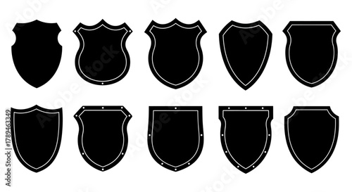 Collection of ten black silhouette shield shapes with grunge texture isolated on white background