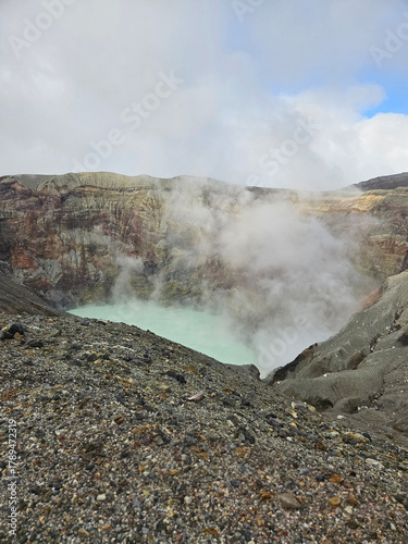 Unique landscape of the crater of Nakadake in Mount Aso Japan with rock and mountain background