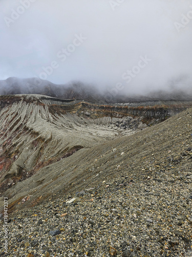 Unique landscape of the crater of Nakadake in Mount Aso Japan with rock and mountain background