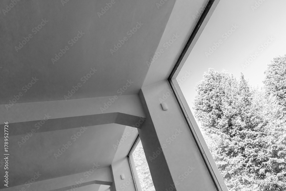 Fototapeta premium A stark monochrome interior scene featuring angled walls and expansive windows