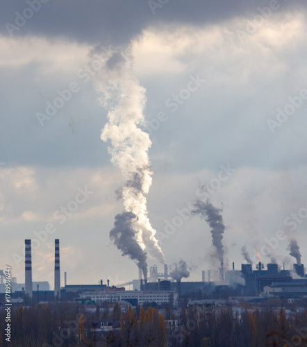 A large cloud of smoke is rising from a factory