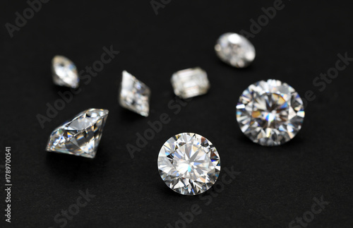A collection of diamonds and other gemstones are displayed on a black background