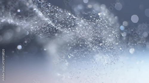 Spraying Water with Bokeh on Gradient Background in Light Blue Color Tone and Blurred Circular Lights with Shiny Wet Water Texture