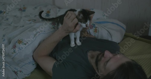 Man Waking up in Bed with Smartphone and Kitten. 4K 10-bit