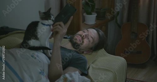 Man Waking up in Bed with Smartphone and Kitten. 4K 10-bit