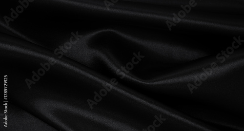 Smooth elegant black silk or satin luxury cloth texture as abstract background. Luxurious background design