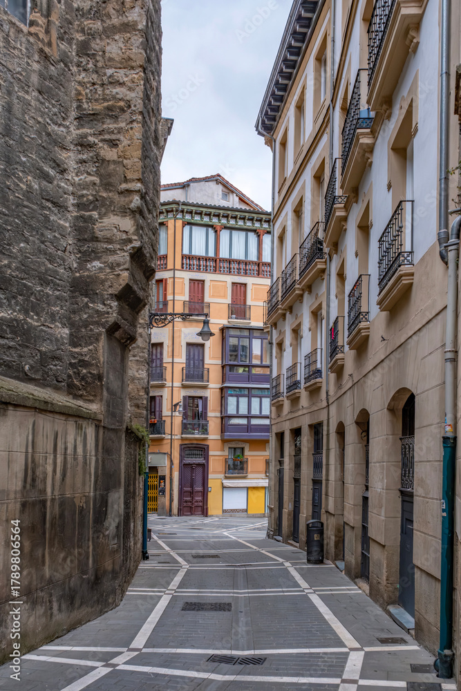 Naklejka premium Narrow Street with Colorful Buildings and Medieval Wall, Pamplona Old Town