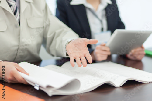 打ち合わせをする作業着姿の男性とビジネスウーマン 