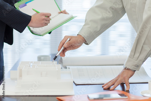 打ち合わせをする作業着姿の男性とビジネスウーマン 