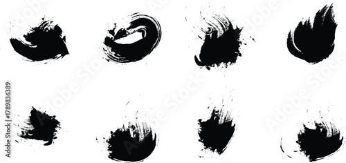 Set of eight abstract black ink brush stroke splatters and smudges on a white background