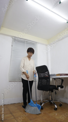 women are cleaning an office together.white office environment, showing teamwork and attention to cleanliness in the workplace.