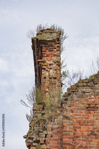 The ruins of an old brick fortress with green grass growing on it