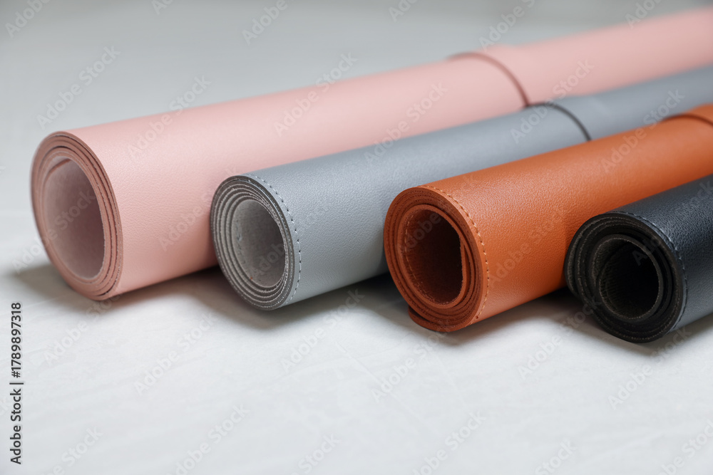 Fototapeta premium Different rolled computer mats on light grey table, closeup