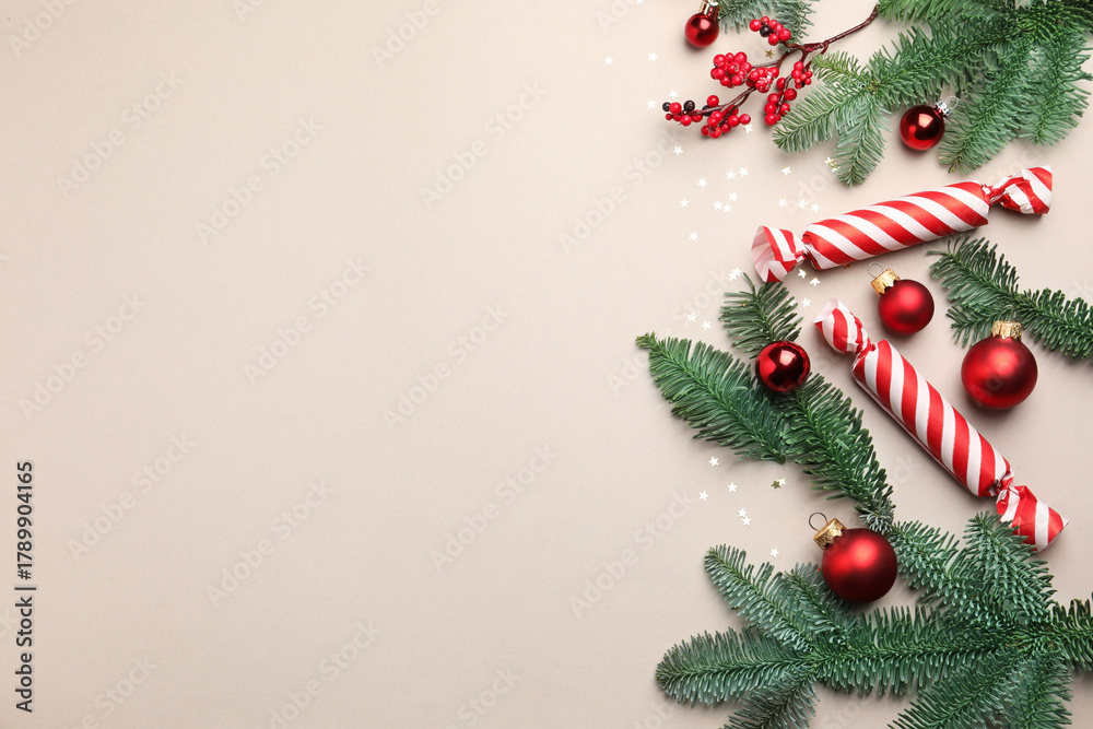 Naklejka premium Fir tree branches, candies and Christmas decor on light background, flat lay. Space for text
