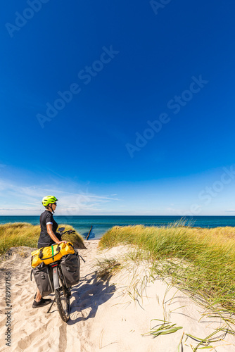 Cyclist with e-bike on baltic sea coast path in Wustrow Germany