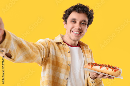 Young man with tasty hot do...