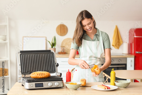 Young woman cooking hot dog...