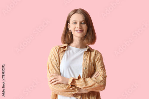 Young woman smiling on pink...