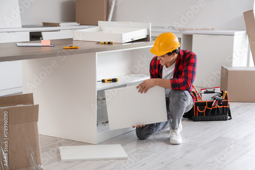Male worker installing cabi...