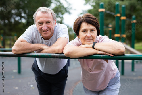 Elderly man and woman posing in open-air sports bars complex