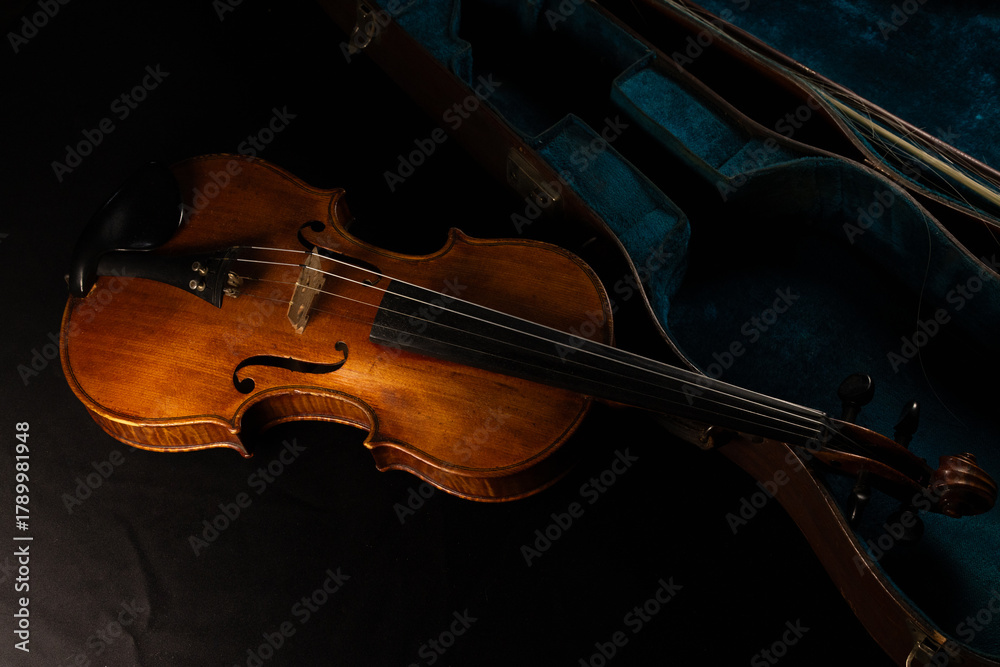 Fototapeta premium vieux violon posé sur un bel étui ancien de couleur bleu vert.