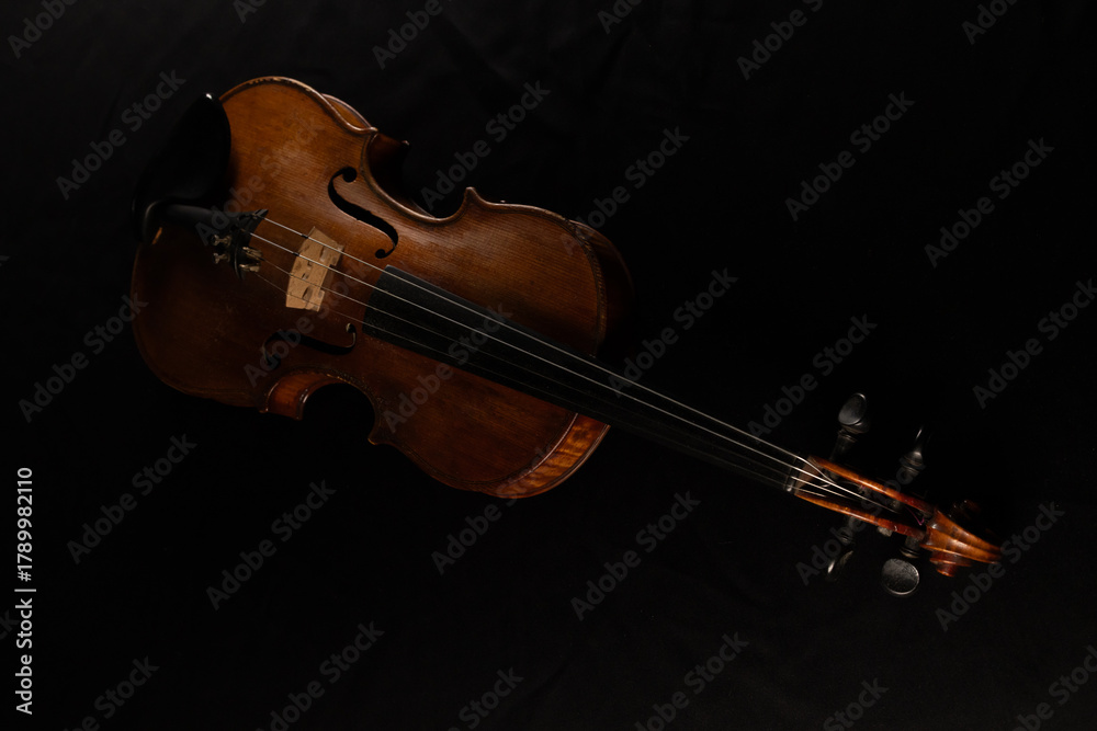 Fototapeta premium vieux violon posé sur une table recouverte d'un tissu noir