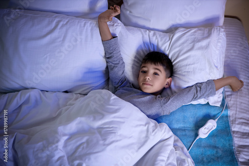 Cute little boy lying under...