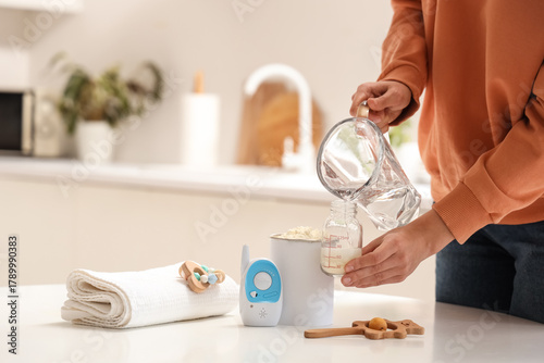 Woman preparing baby milk f...